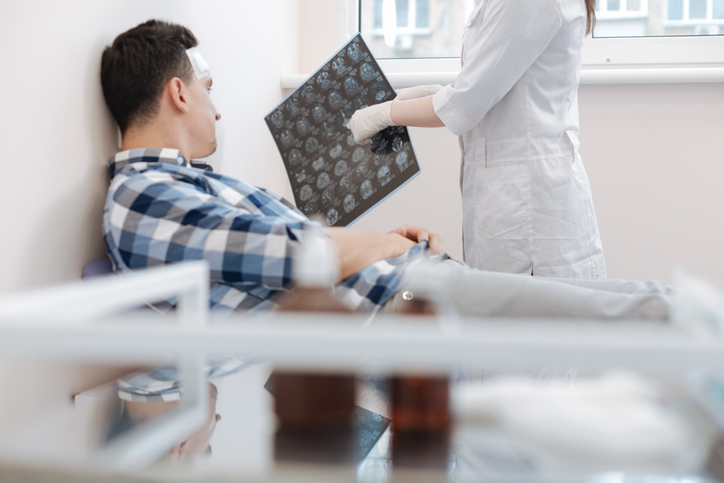 A doctor shows a patient the scan of their traumatic brain injury.